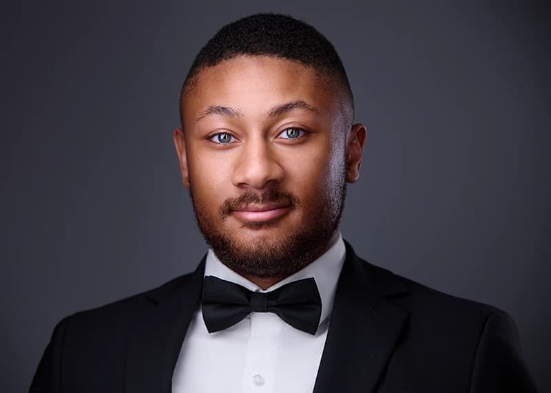 Professional headshot with clean dark background
