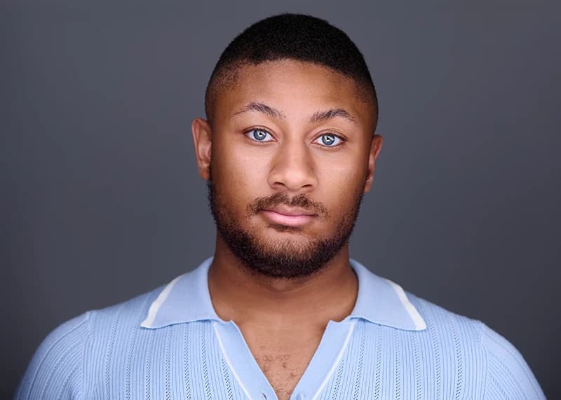 Professional headshot in a relaxed, approachable style with a softer expression