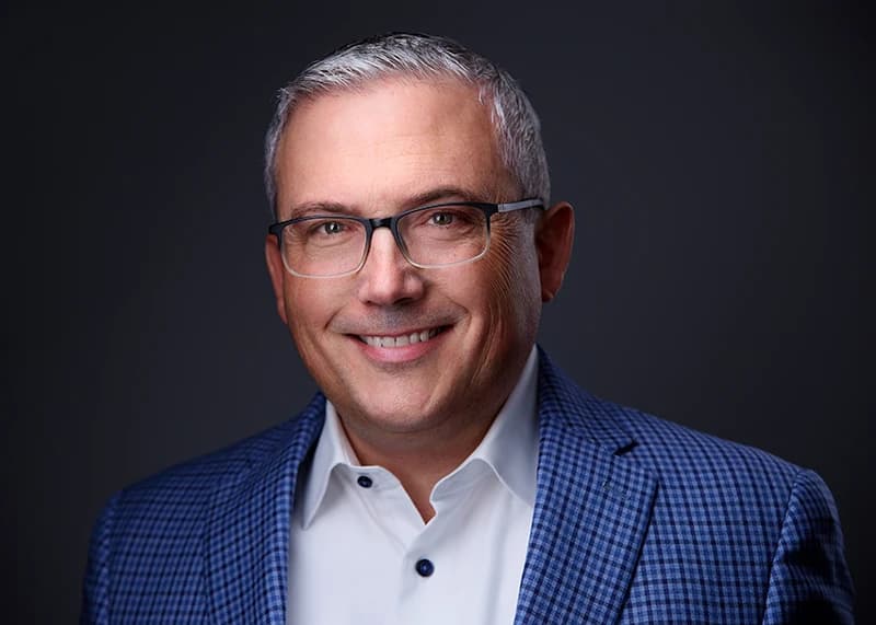 Professional headshot of man wearing glasses