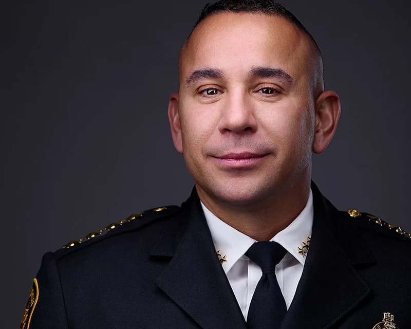 Professional headshot of a man with very short, closely cropped hair