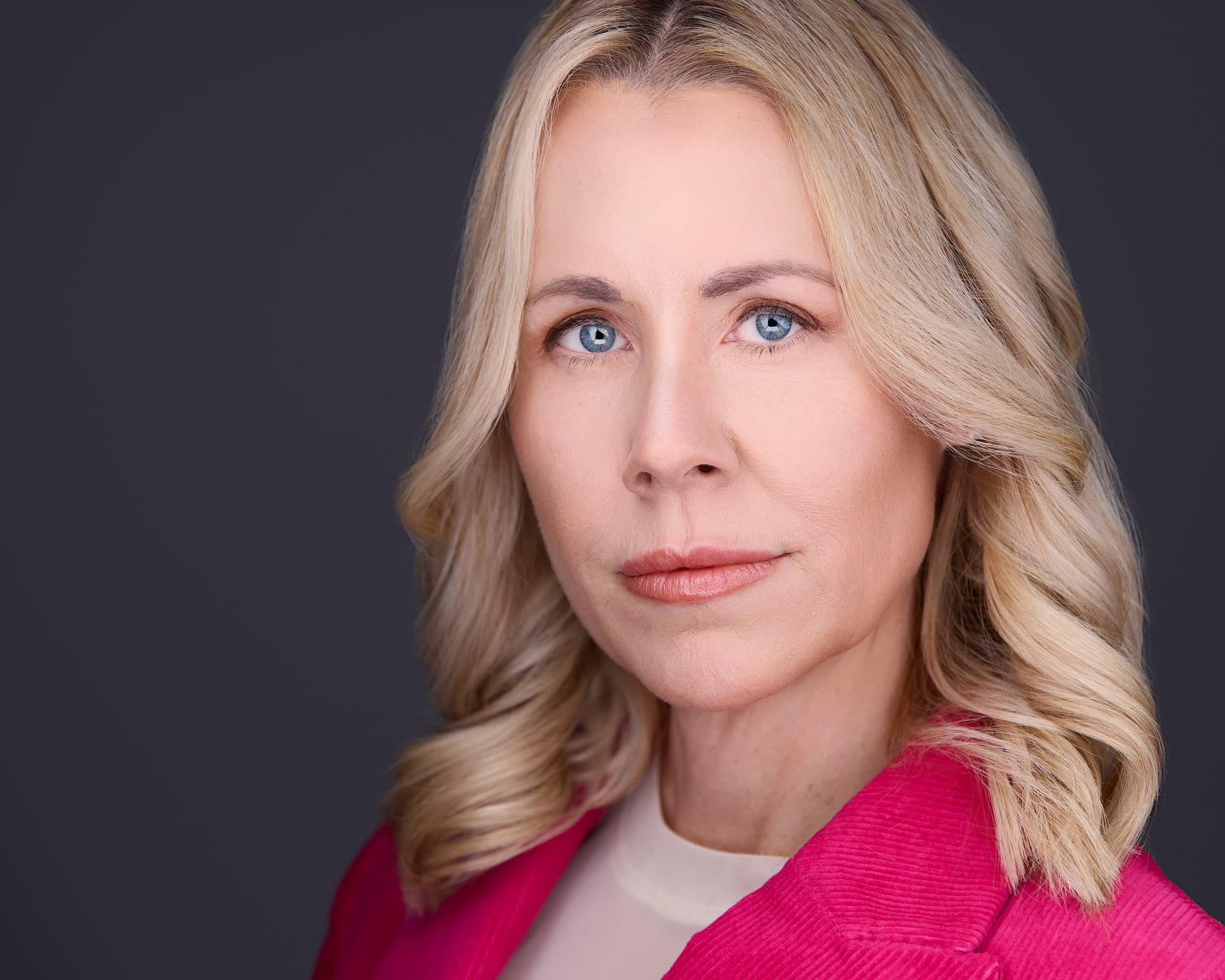 Headshot tips for women - professional styling in pink blazer