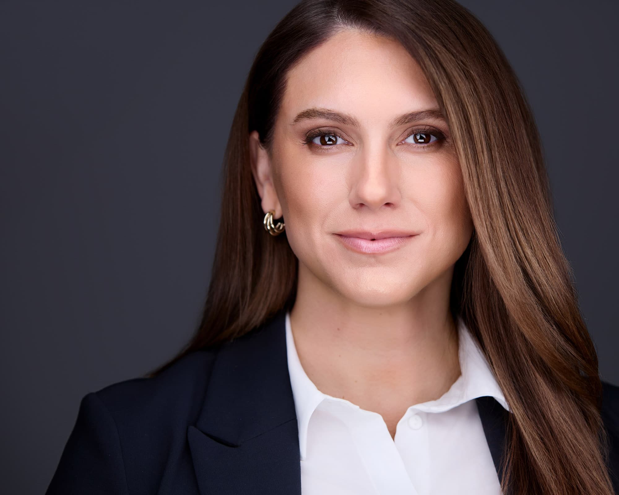 Professional headshot of woman in classic navy blazer