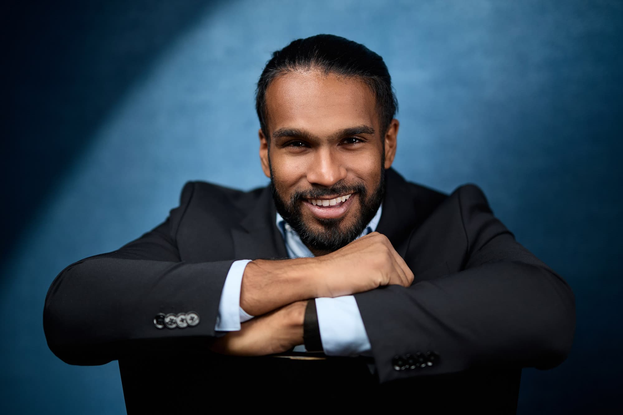 Men's headshot pose against blue background