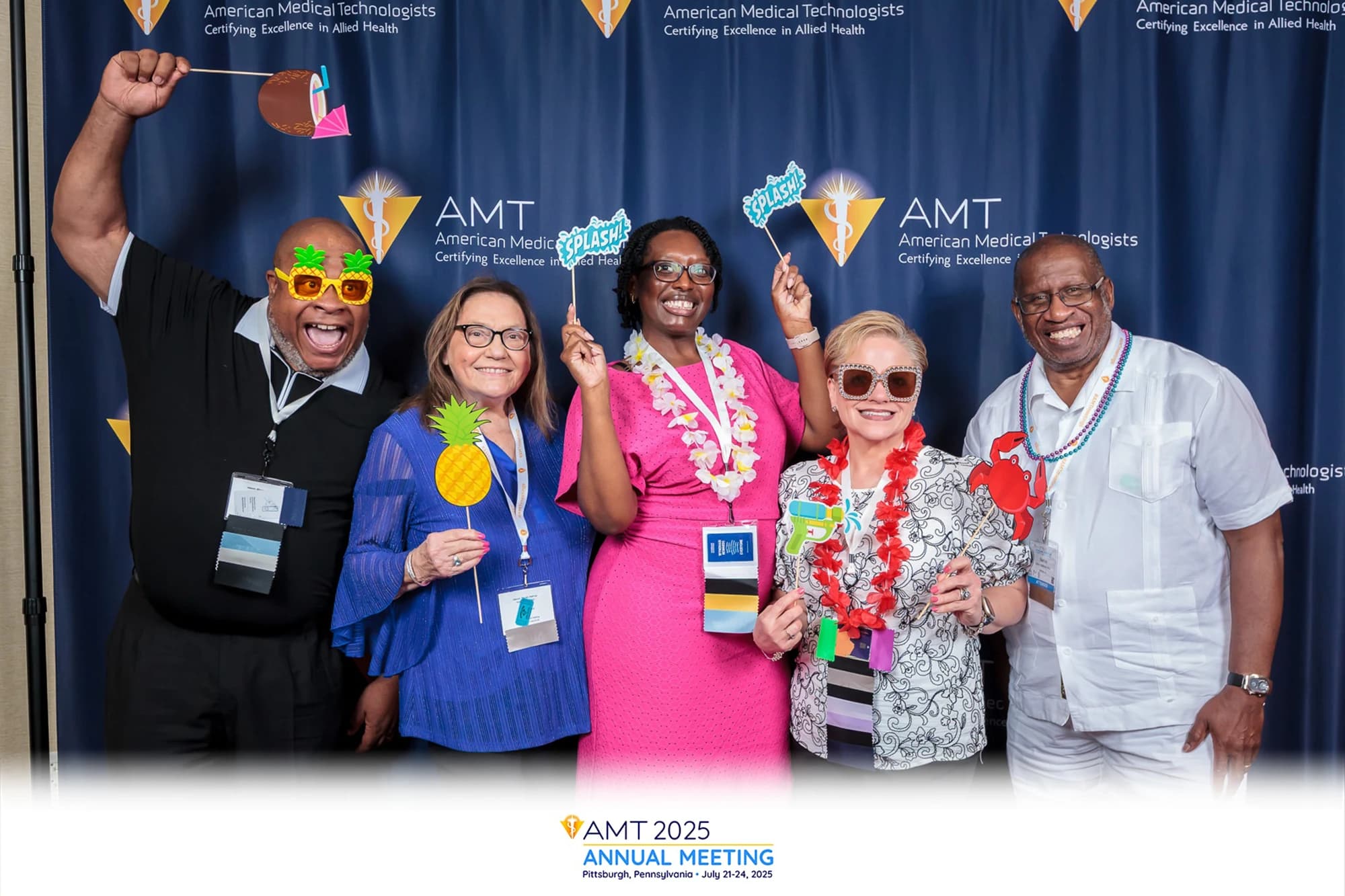 Corporate event guests posing at branded step and repeat photo station
